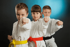 three kids performing a karate stance