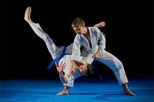 a karate student performing a flip on another student