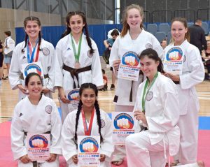 a group of karate students holding certificates of appreciation