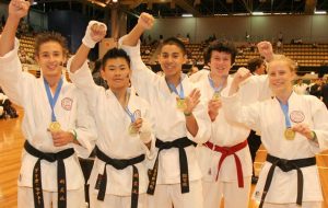 5 karate students cheering with their medals
