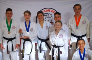 students wearing medals, all have black belts