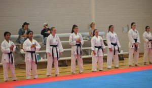 a row of young girls wearing karate black belts