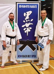 two students standing in front of the gkr karate black belt open tournament
