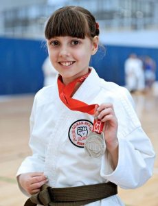 a young girl holding a medal