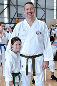 a middle aged man standing with his daughter