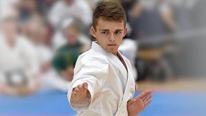 a young boy performs a karate stance