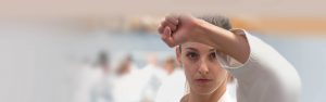 a young women wearing a gi performs a block