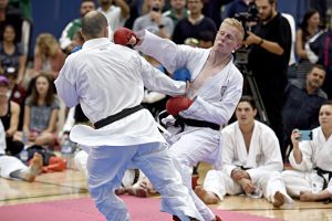 two karate students wearing black belts, performing karate moves