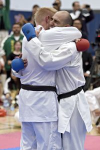 two men hug it out after competition against each other in a gkr karate tournament