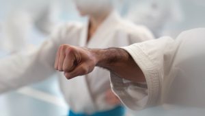 an older gkr karate man puts his hand into a fist