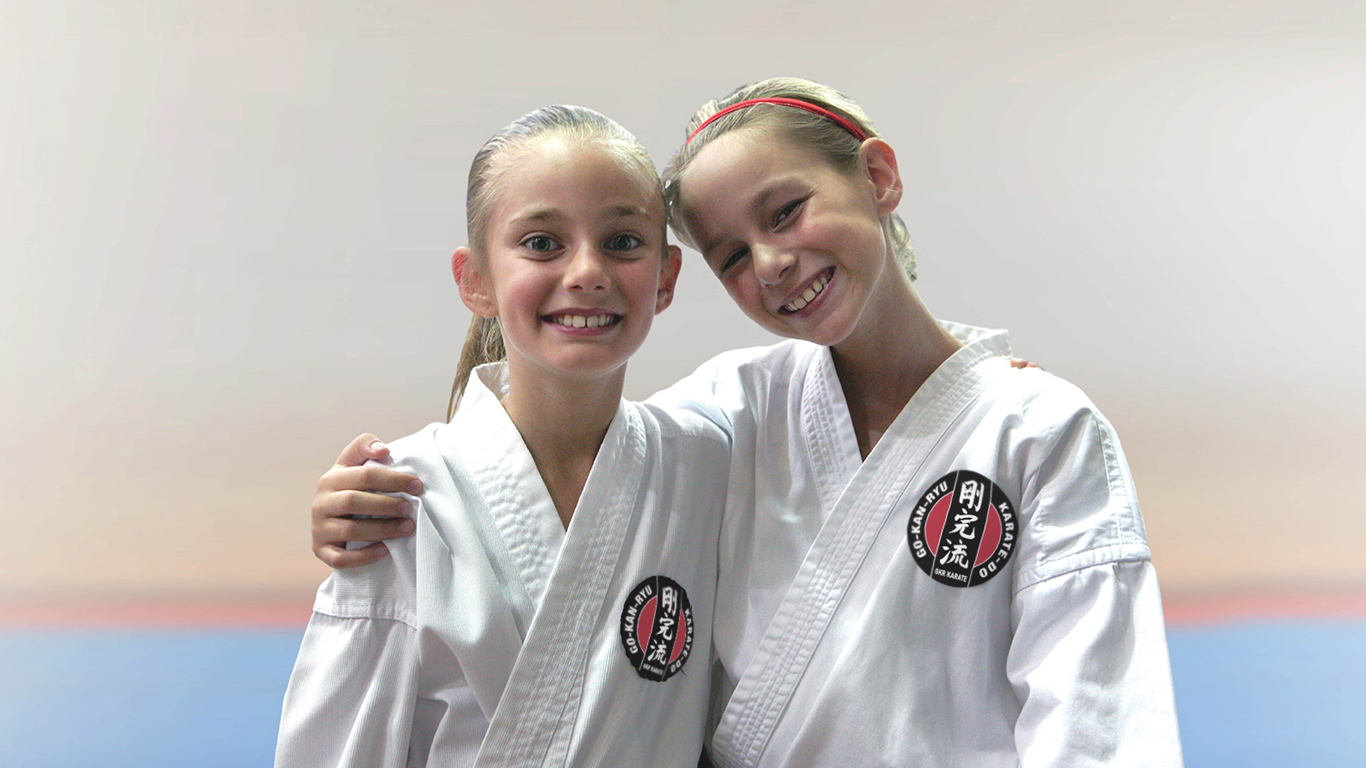 two girls wearing gkr karate gi posing for the camera. the search for happiness
