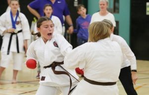 Two young girls performing karate moves against each other