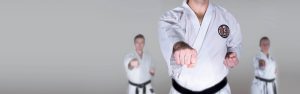 three karate students with black belts