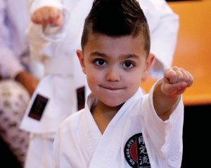 small boy with clenched fist wearing gkr karate gi