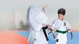 an older man teaches a young boy how to tie his belt