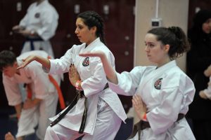 two teenage girls perform karate moves