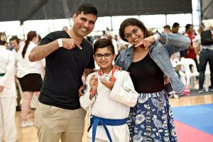 an indian family posing for the camera, celebrating there youngest getting a medal