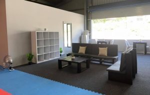 the interior of cameron park gkr karate with two couches, a bookshelf and a window behind that shows outside