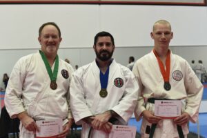 three karate students showing there certificate of participation