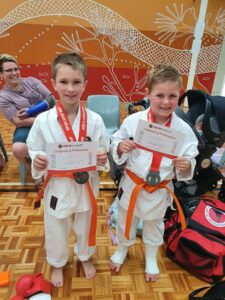 two karate students holding up certificate of participations