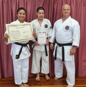 three people get certificates of participation. they are all black belts