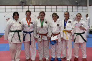 six karate students celebrating there certificate's and medals