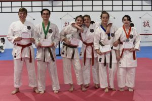 a group of students stand together wearing different belts