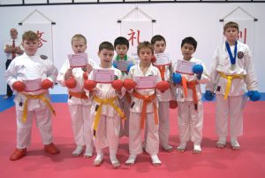 8 young karate students celebrating with there certificate of participation