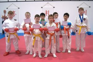 8 young karate students celebrating with there certificate of participation