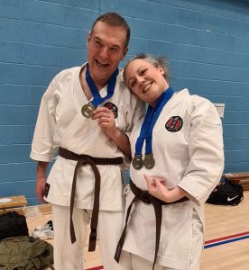 two brown belt students celebrating there medals