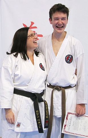 A mother and son wearing GKR Karate gis. The mother is looking proudly up at her son.