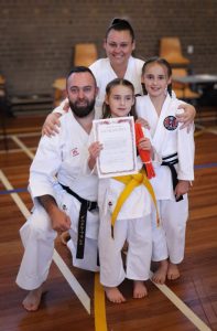 A mother and father with their two daughters after a karate grading.