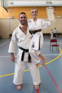 A father and daughter dressed in gis after a karate grading