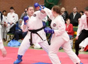 two students compete against each other in karate, both are wearing black belts