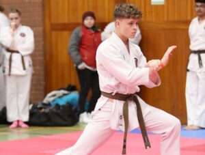 a young boy wears a brown belt