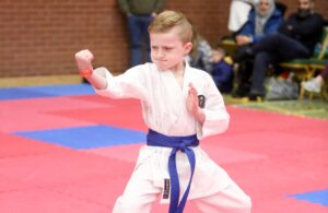 a small boy wearing a gkr karate gi, and had a blue belt