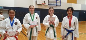 four karate students getting there medals and certificate of appreciation